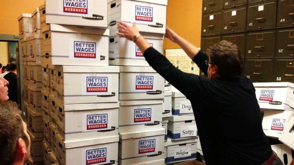 Deputy Secretary of State for elections handles boxes containing 134,899 petitions to raise the Nebraska minimum wage, enough to get the wage hike measure on the November ballot.