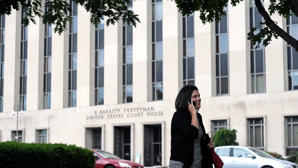 A woman talks on the phone in front of the U.S. Courthouse in Washington, Thursday, June 6, 2013, where the secret Foreign Intelligence Surveillance Court resides. (AP Photo/Cliff Owen)