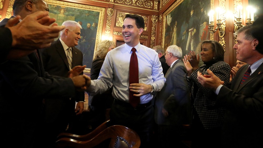 Wisconsin Republican Gov. Scott Walker is greeted by members of his staff and cabinet at the Wisconsin State Capitol building in Madison, Wis., Nov. 5, 2014. (Photo by John Hart/Wisconsin State Journal/AP)