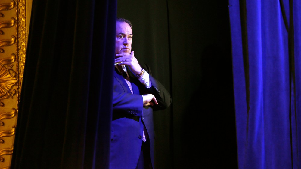 Former Arkansas Gov. Mike Huckabee waits backstage before speaking during the Freedom Summit, Jan. 24, 2015, in Des Moines, Iowa. (Photo by Charlie Neibergall/AP)