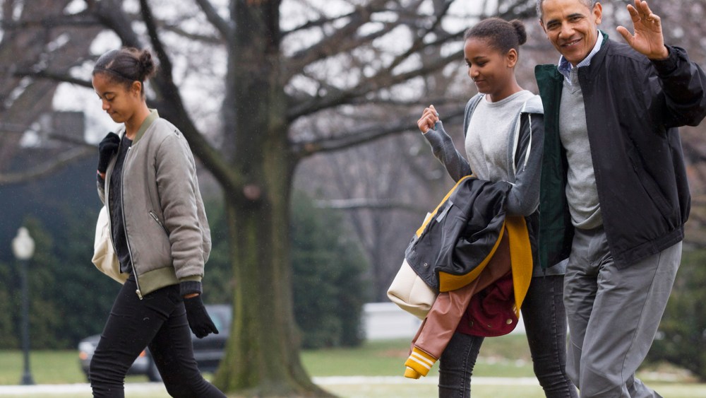 President Barack Obama, right, waves to the media with daughters Sasha and Malia, left, on Jan. 5, 2014. (Photo by Jacquelyn Martin/AP)