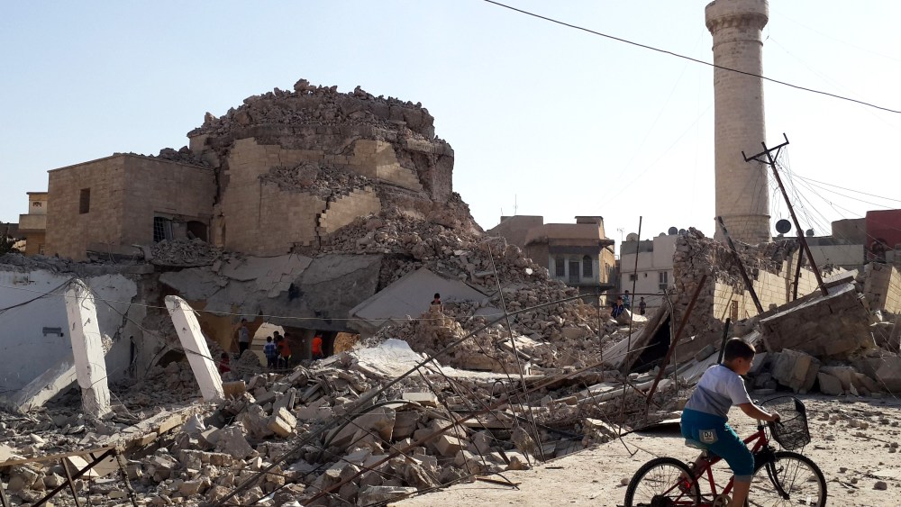 A bicyclist rides by the remnants of the old Mosque of The Prophet Jirjis, destroyed by Islamic State militants, in central Mosul, Iraq, on July 27, 2014. (File Photo/AP)