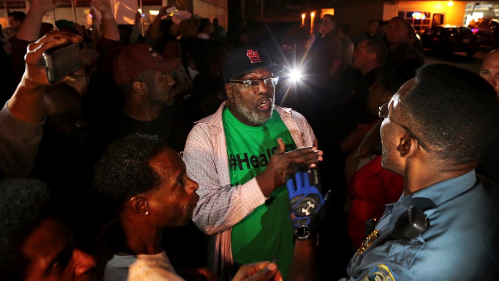 Protesters argue with a Ferguson sergeant who was trying to get them to disperse the area on West Florissant Avenue in Ferguson late Tuesday, Sept. 23, 2014.