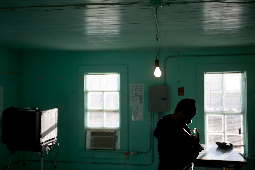 A poll manager places a "I Voted" sticker on her sweatshirt after taking her turn to cast her ballot inside the old Hoggards Mill Courthouse, now a polling site for Baker County, Nov. 4, 2014, in Newton, Ga. (Photo by David Goldman/AP)