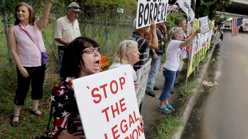 Barbie Miller, left, yells as she joins demonstrators outside the Mexican Consulate Friday, July 18, 2014, in Houston, Texas.
