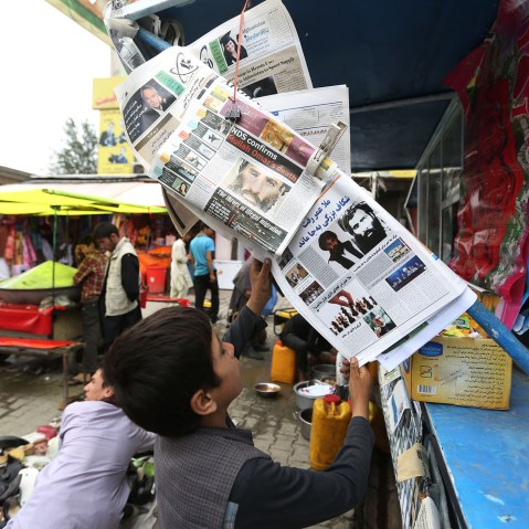 An Afghan boy reads a local newspaper at a newsstand where local newspapers carry headlines about the new leader of the Afghan Taliban, Mullah Akhtar Mohammad Mansoor, in Kabul, Afghanistan, Aug. 1, 2015. (Photo by Rahmat Gul/AP)