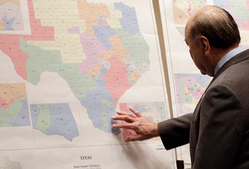 In this May 30, 2013 file photo, Texas state Sen. Juan "Chuy" Hinojosa looks at maps on display prior to a Senate Redistricting committee hearing, in Austin, Texas.  (Photo by Eric Gay/AP)