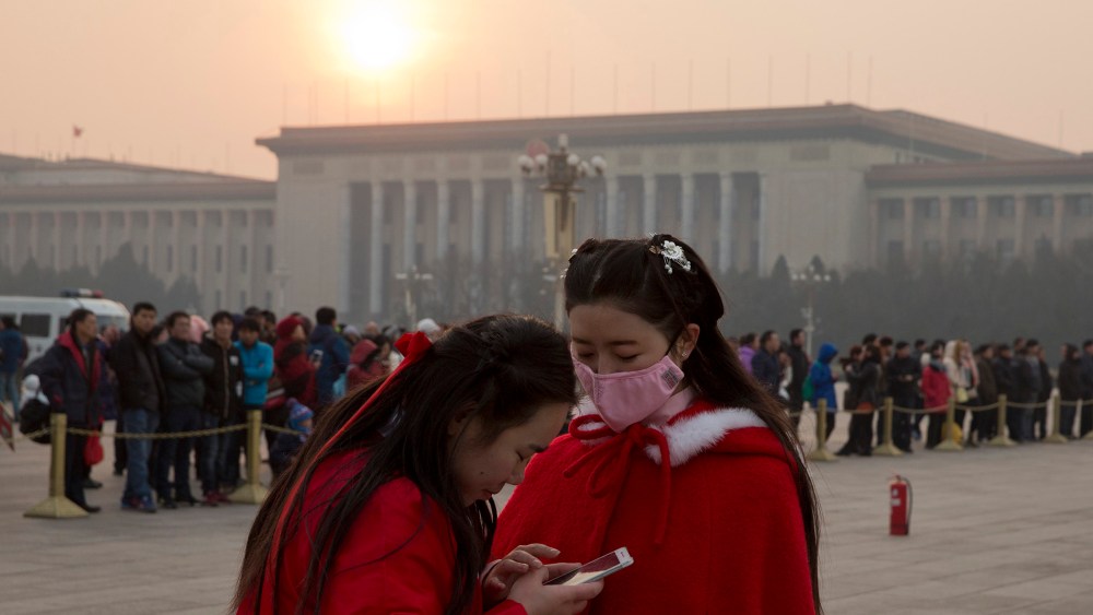 A Chinese woman wears a mask as she visits Tiananmen Square in Beijing, China, Dec. 19, 2015. (Photo by Ng Han Guan/AP)