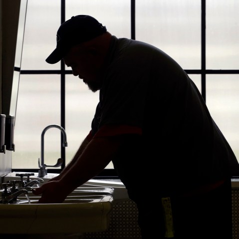 A worker with the West Virginia department of General Services flushes the water as he opens a rest room on the first floor of the State Capitol in Charleston, W.Va., Jan. 13, 2014.