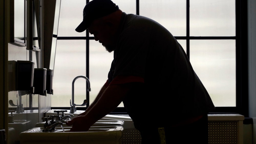 A worker with the West Virginia department of General Services flushes the water as he opens a rest room on the first floor of the State Capitol in Charleston, W.Va., Jan. 13, 2014.
