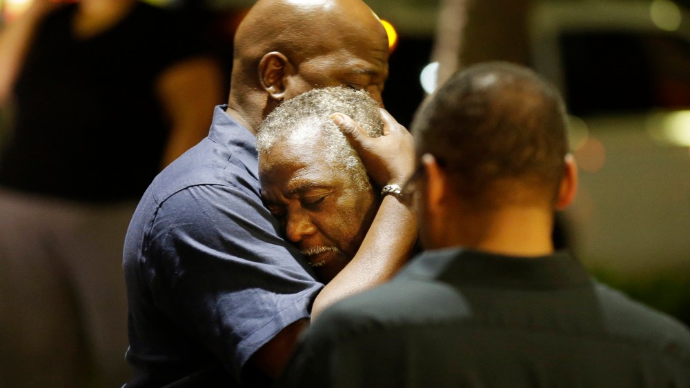 Worshippers embrace following a group prayer across the street from the scene of a shooting, June 17, 2015, in Charleston, S.C. (Photo by David Goldman/AP)