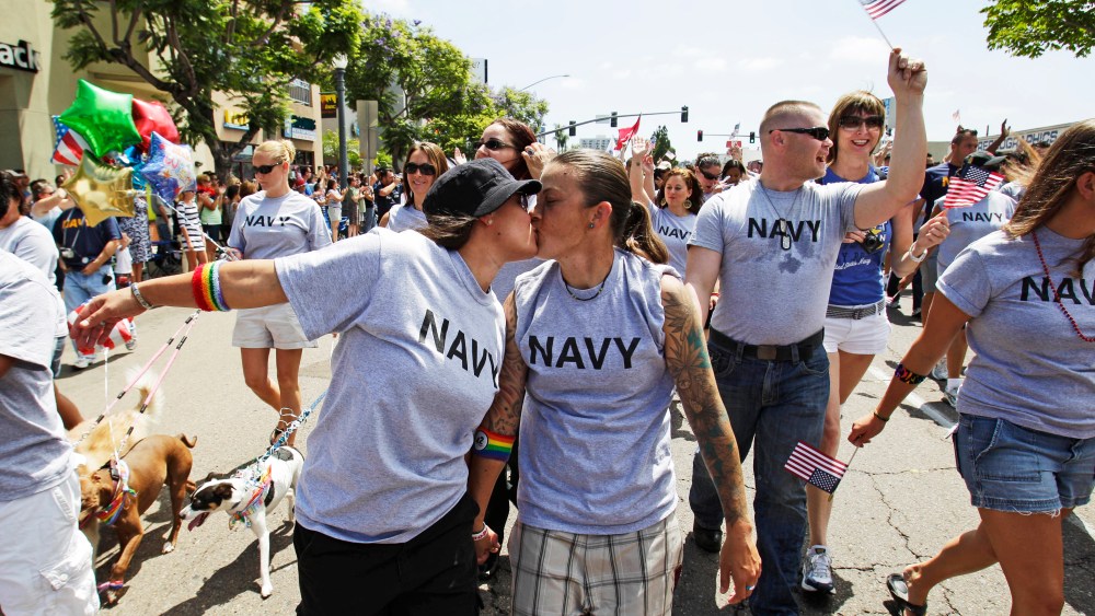 Two women, both active duty sailors in the Navy, kiss as they march in a Gay Pride Parade in San Diego.