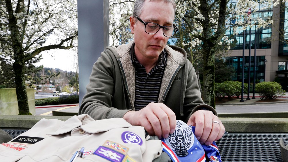 Geoff McGrath displays his Boy Scout scoutmaster uniform shirt and other scout items for the Seattle troop he led, April 1, 2014.