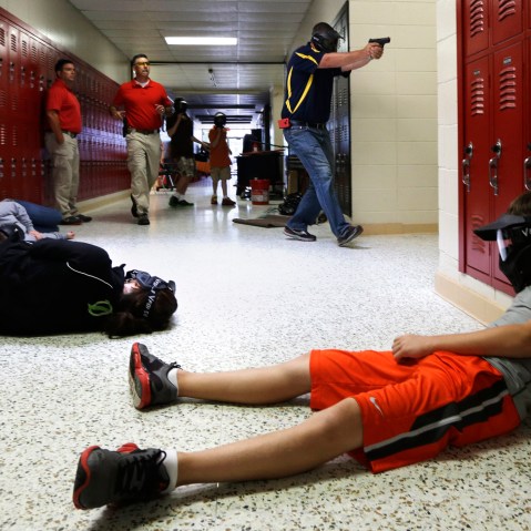 A Clarksville Schools faculty member carries an air-powered practice handgun during a training exercise in Clarksville, Ark., July 11, 2013.