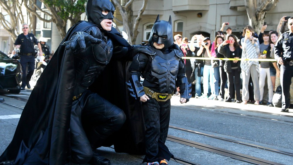 Miles Scott, dressed as Batkid, right, walks with Batman before saving a damsel in distress in San Francisco on Nov. 15, 2013.