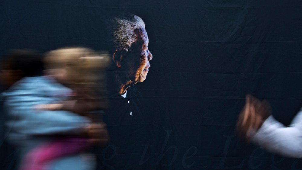 A woman walks past a banner showing former president Nelson Mandela at the Nelson Mandela Centre of Memory in Johannesburg, Dec. 9, 2013.