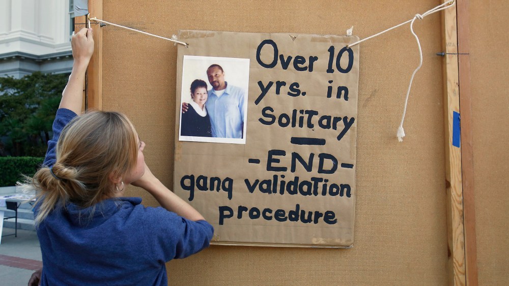 Georgia Valentine hangs a poster calling for reform in the use of solitary confinement in California prisons, Oct. 9, 2013.