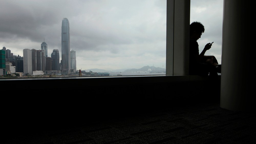A man uses his smartphone in Hong Kong, June 16, 2013.