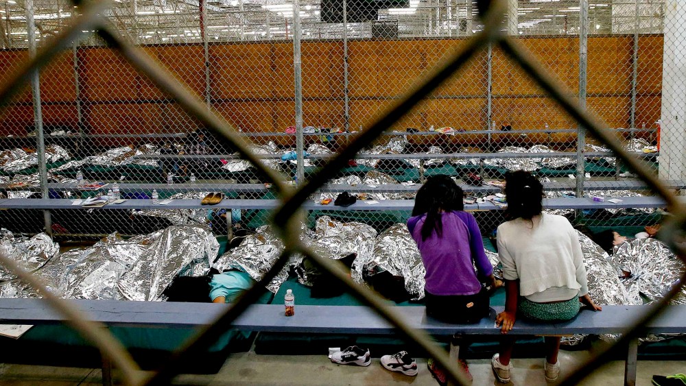 Two young girls watch a World Cup soccer match on a television from their holding area at the U.S. Customs and Border Protection Nogales Placement Center on June 18, 2014, in Nogales, Ariz. (Photo by Ross D. Franklin/AP)