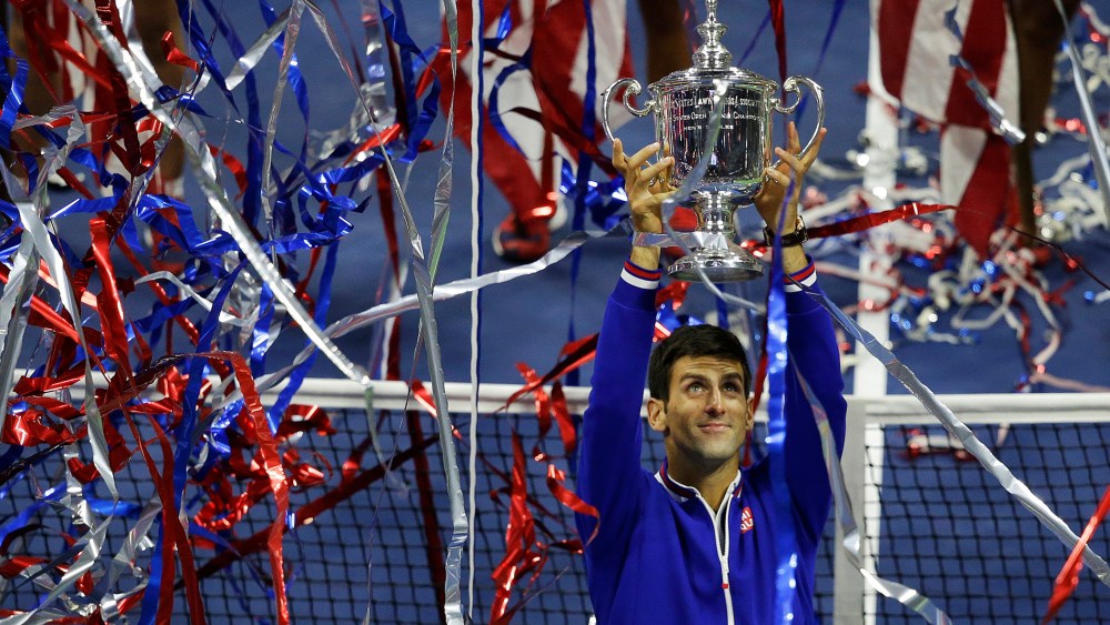 Novak Djokovic, of Serbia, holds up the championship trophy after defeating Roger Federer, of Switzerland, in the men's championship match of the U.S. Open tennis tournament, Sep. 13, 2015, in New York. (Photo by Seth Wenig/AP)