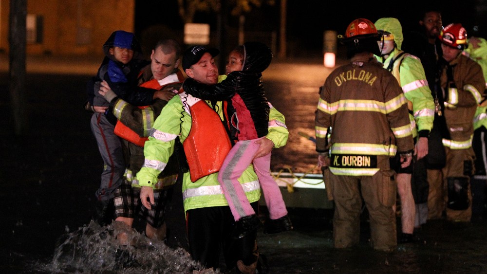 Rescue crews help residents at the Guardian Court Apartments evacuate after flooding in the area on April 3, 2015 in Louisville, Ky. (Photo by Michael Clevenger/The Courier-Journal via AP)