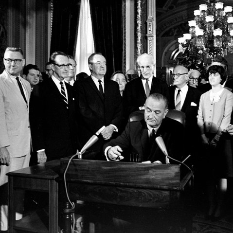 In this Aug. 6, 1965, photo, President Lyndon Baines Johnson signs the Voting Rights Act of 1965 in a ceremony in the President's Room near the Senate Chambers on Capitol Hill in Washington.   (Photo by AP)