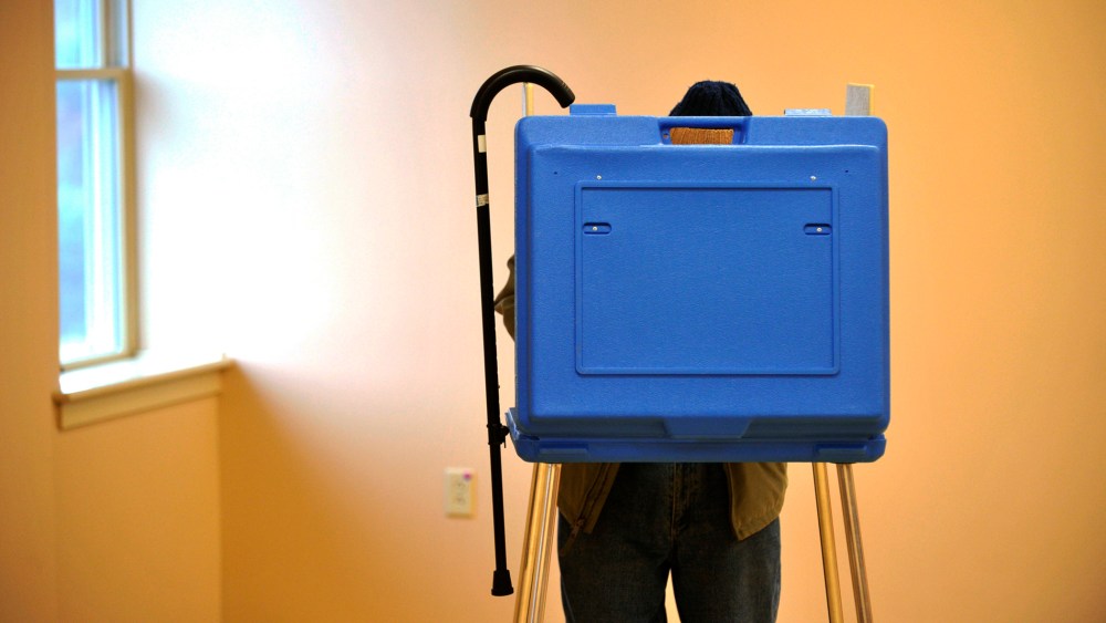 Ninety-one-year-old Dave Silverman hangs his cane on the booth while voting in State College, Pa., Nov. 5, 2013.
