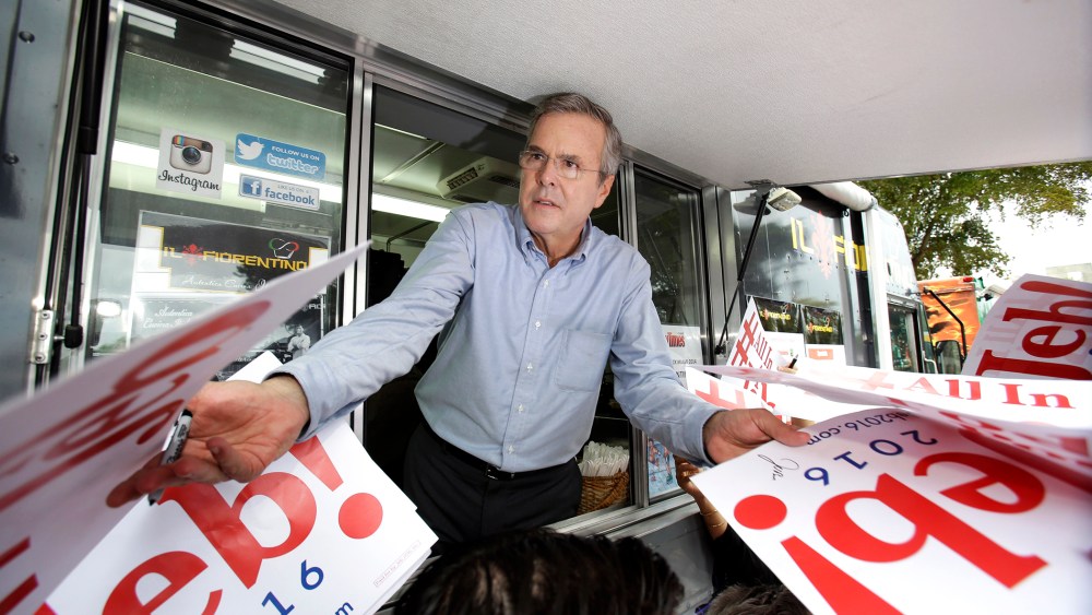 Former Florida Gov. Jeb Bush signs autographs from the window of a food truck after he formally announced that he would join the race for president with a speech at Miami Dade College, June 15, 2015, in Miami. (Photo by Wilfredo Lee/AP)