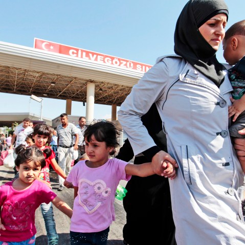 Syrian refugees pass through the Turkish border, Saturday, Aug. 31, 2013.