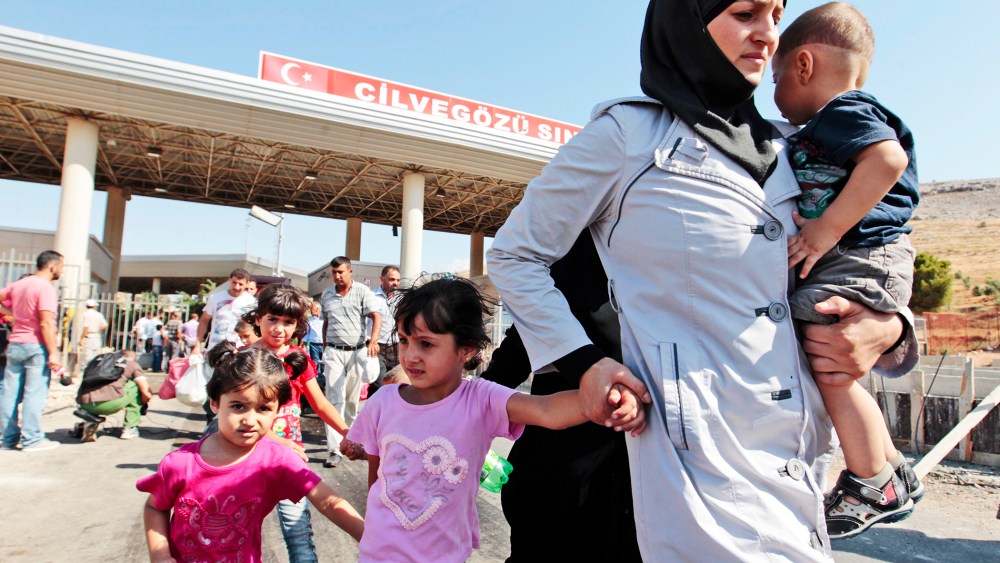 Syrian refugees pass through the Turkish border, Saturday, Aug. 31, 2013.