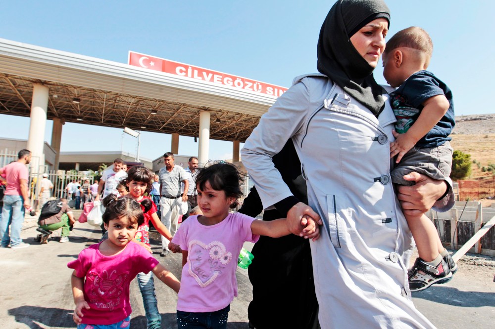 Syrian refugees pass through the Turkish border, Saturday, Aug. 31, 2013.