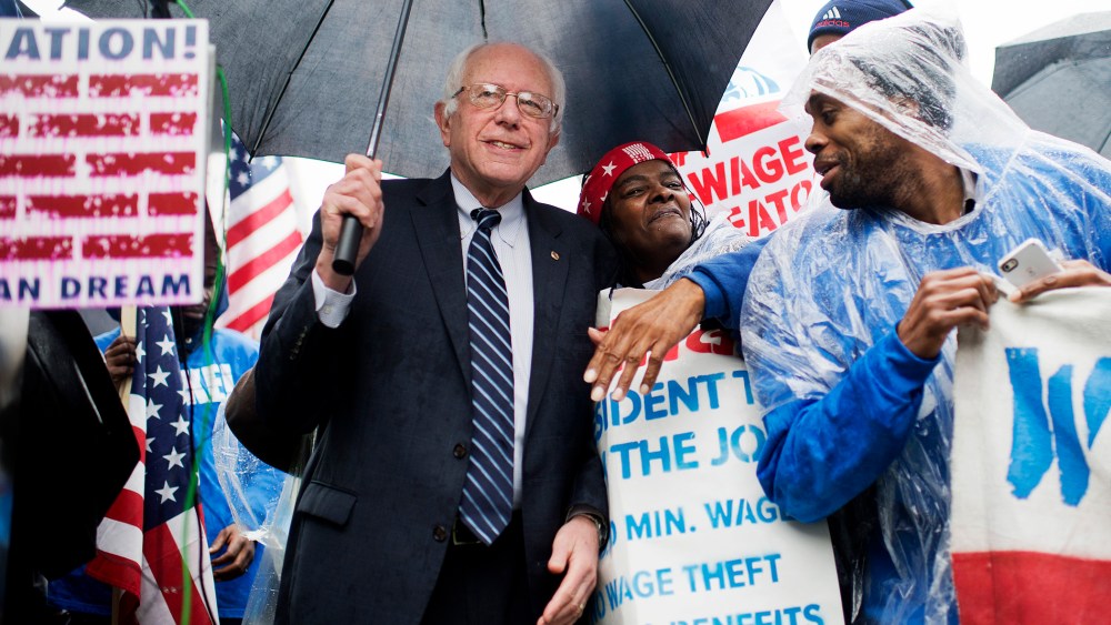 On the day of a Republican presidential debate, Sen. Bernie Sanders, I-Vt., attends a rally in Upper Senate Park with striking workers to call for a minimum wage of $15 per hour, Nov. 10, 2015. (Photo By Tom Williams/CQ Roll Call/AP)