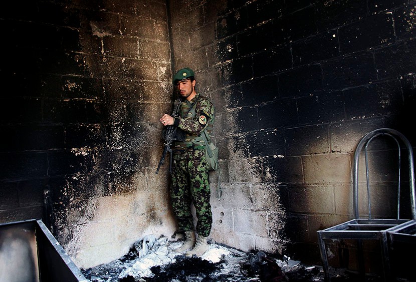 An Afghan army soldier stands guard in the destroyed courthouse in Farah, western Afghanistan, Thursday, April 4, 2013. Suicide bombers disguised as Afghan soldiers stormed a courthouse Wednesday in a failed bid to free more than a dozen Taliban...