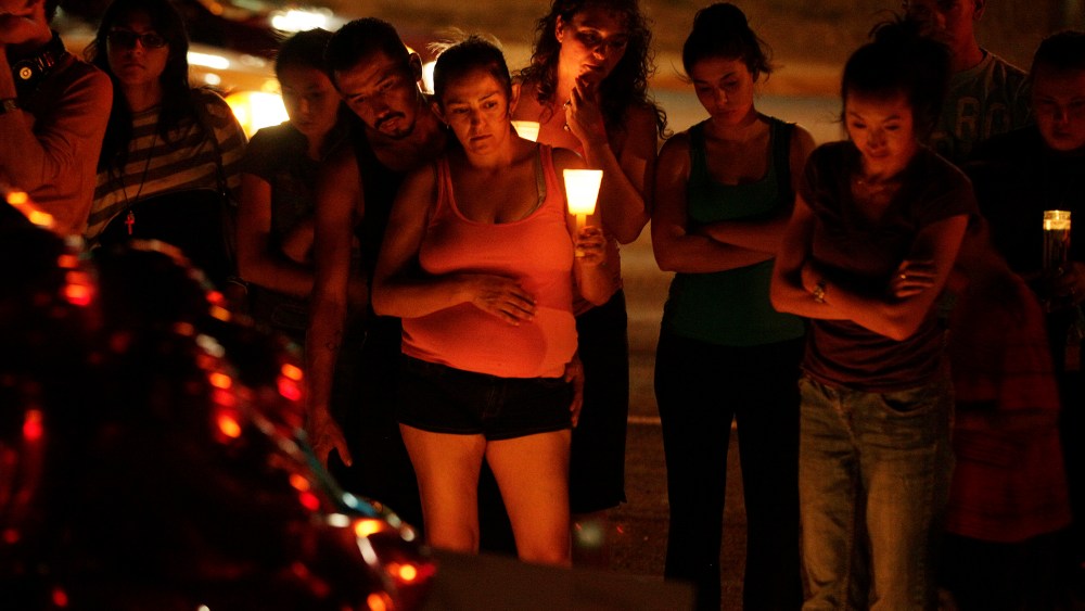 People hold candles as they view a growing memorial on July 21, 2012, near the movie theater in Aurora, Colo. where a gunman killed at least 12 people and wounded dozens of others. (Photo by Ted S. Warren/AP)