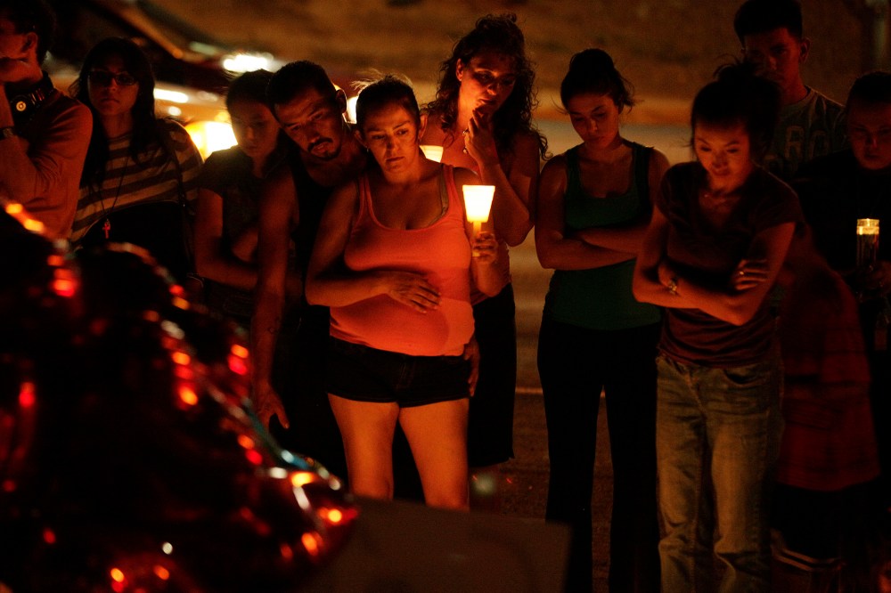 People hold candles as they view a growing memorial on July 21, 2012, near the movie theater in Aurora, Colo. where a gunman killed at least 12 people and wounded dozens of others. (Photo by Ted S. Warren/AP)