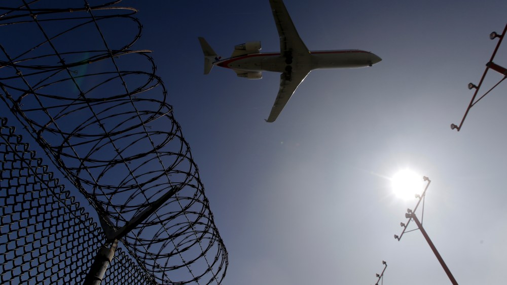 In this Feb. 6, 2015 photo, a passenger jet flies over the perimeter fence at the Los Angeles International Airport as it lands. (Photo by Chris Carlson/AP)