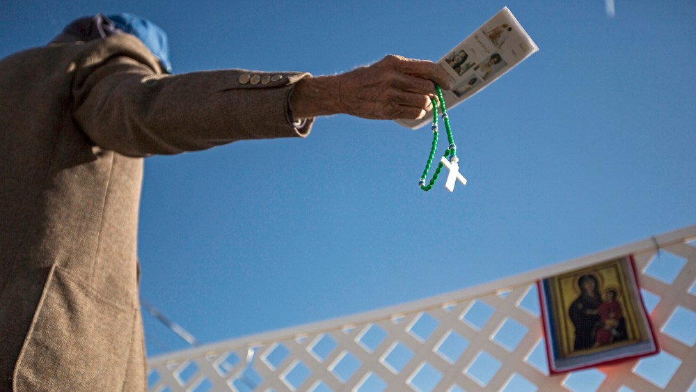 A protester waves anti-abortion literature in the direction of a reproductive health clinic on Nov. 14, 2013, in Albuquerque, N.M.
