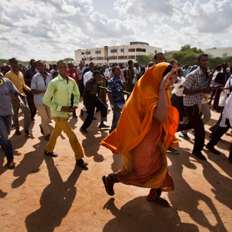 Members of the public run to get a glimpse as authorities display the bodies of the alleged attackers before about 2,000 people in a large open area in central Garissa, Kenya, April 4, 2015. (Photo by Ben Curtis/AP)