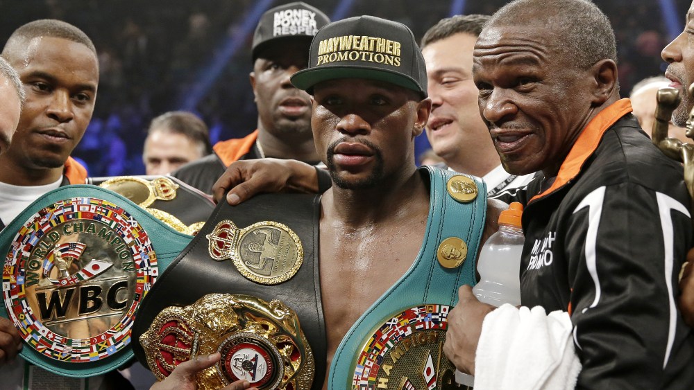 Floyd Mayweather Jr. poses with his champion's belts and his father, head trainer Floyd Mayweather Sr., after his victory over Manny Pacquiao, from the Philippines, in their welterweight title fight on May 2, 2015 in Las Vegas. (Photo by Isaac Brekken/AP)