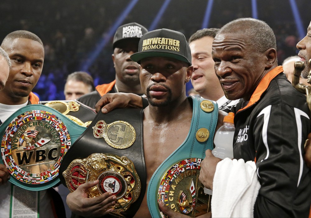 Floyd Mayweather Jr. poses with his champion's belts and his father, head trainer Floyd Mayweather Sr., after his victory over Manny Pacquiao, from the Philippines, in their welterweight title fight on May 2, 2015 in Las Vegas. (Photo by Isaac Brekken/AP)