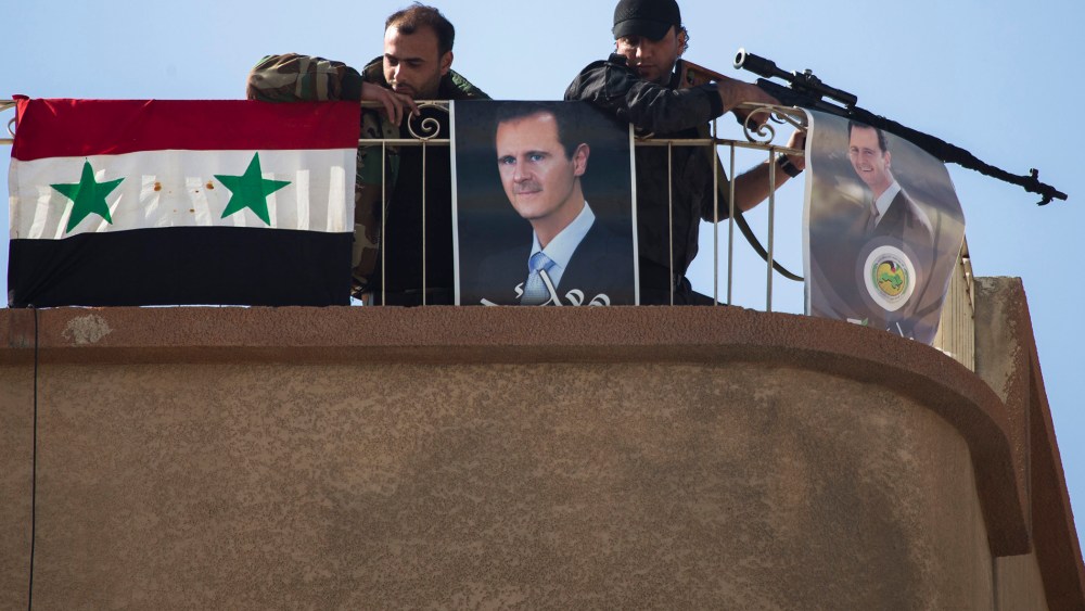 Syrian solders keep watch on a roof with portraits of Syrian President Bashar Assad in Al-Tall, a town of northern outskirts of Damascus, Syria, March 3, 2016. (Photo by Pavel Golovkin/AP)