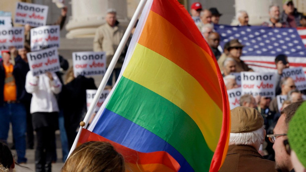 Supporters of Arkansas' law banning same sex marriage, top, hold a rally as a protestor waves a rainbow flag at the Arkansas state Capitol in Little Rock, Ark. on Nov. 19, 2014.