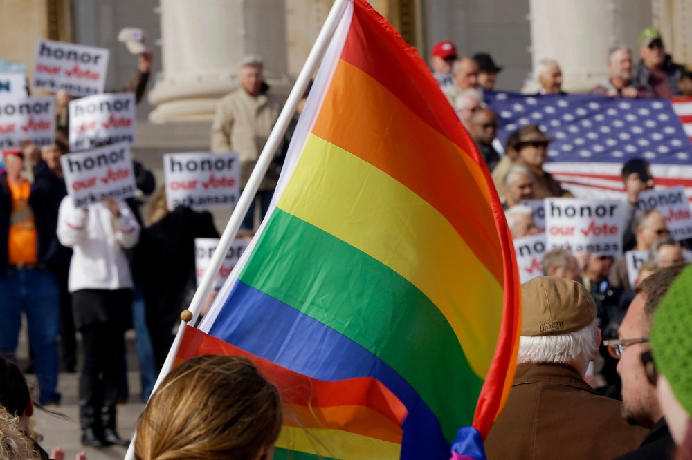Supporters of Arkansas' law banning same sex marriage, top, hold a rally as a protestor waves a rainbow flag at the Arkansas state Capitol in Little Rock, Ark. on Nov. 19, 2014.