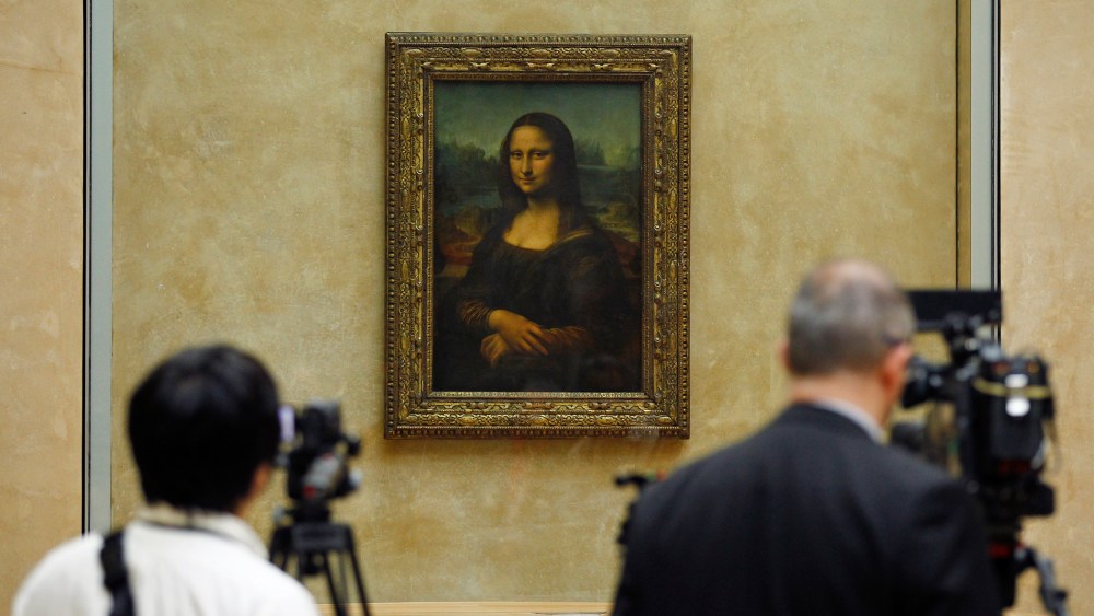 Members of the media are gathered next to the Mona Lisa, during an event to unveil the new lighting of Leonardo da Vinci's painting Mona Lisa, also known as La Joconde, at the Louvre museum in Paris, Tuesday June 4, 2013.