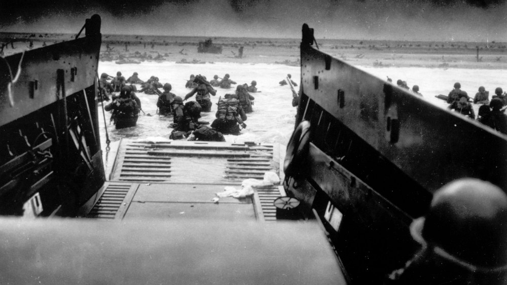 In this image provided by the U.S. Coast Guard, while under attack of heavy machine gun fire from the German coastal defense forces, these American soldiers wade ashore off the ramp of a U.S. Coast Guard landing craft, during the Allied landing operations