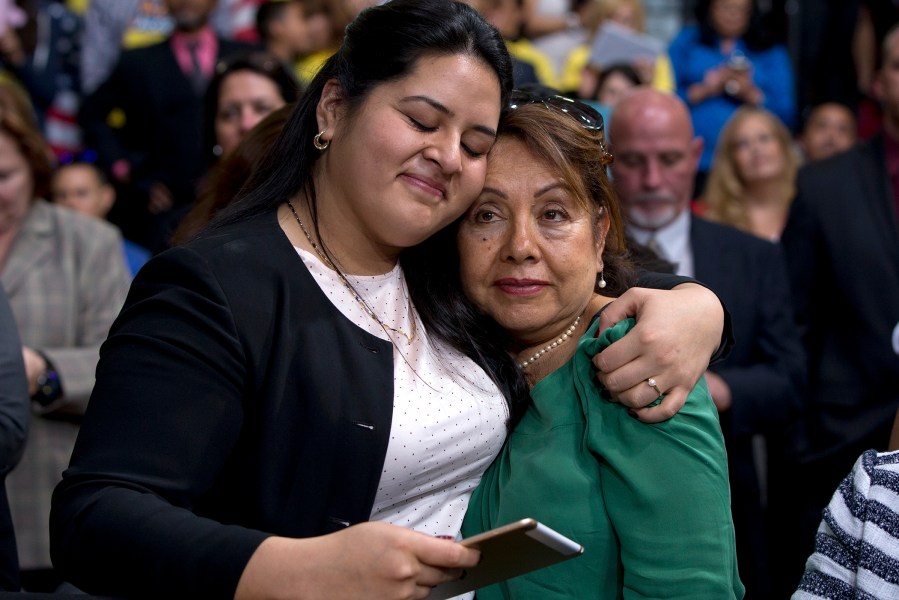 Lorella Preali, left, and her mother Chela Praeli, embrace as President Barack Obama speaks about immigration, Nov. 21, 2014, at Del Sol High School in Las Vegas. (Photo by Carolyn Kaster/AP)