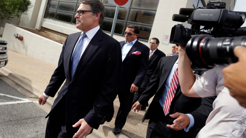 Texas Gov. Rick Perry, left, leaves the Blackwell Thurman Criminal Justice Center after he was booked, Tuesday, Aug. 19, 2014, in Austin, Texas.