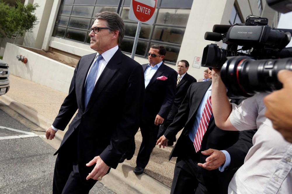 Texas Gov. Rick Perry, left, leaves the Blackwell Thurman Criminal Justice Center after he was booked, Tuesday, Aug. 19, 2014, in Austin, Texas.