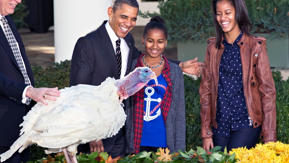 President Barack Obama, with daughters Sasha, center, and Malia, right, carries on the "presidential pardon" tradition at the White House in Washington, D.C., Nov. 21, 2012. (Photo by J. Scott Applewhite/AP)