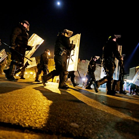 Police in riot gear return to a staging area after lining up to enforce a curfew imposed in the aftermath of rioting following Monday's funeral for Freddie Gray, who died in police custody, May 1, 2015, in Baltimore. (Photo by David Goldman/AP)